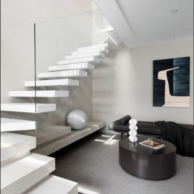Escalera flotante con vigas de acero ocultas y barandillas de vidrio