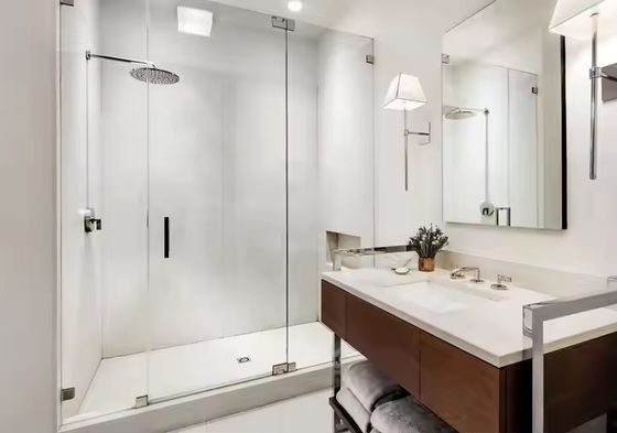 Cabina de ducha moderna con marco dorado, accesorios de hardware personalizables y puerta de vidrio templado con manija para baño
