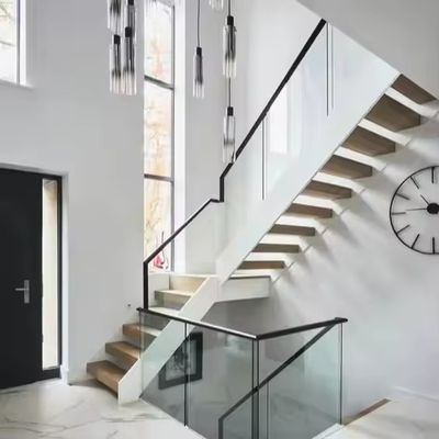 Escaleras rectas interiores modernas Escaleras flotantes de hierro y acero con trampolín de madera y barandilla de vidrio para negocios y apartamentos